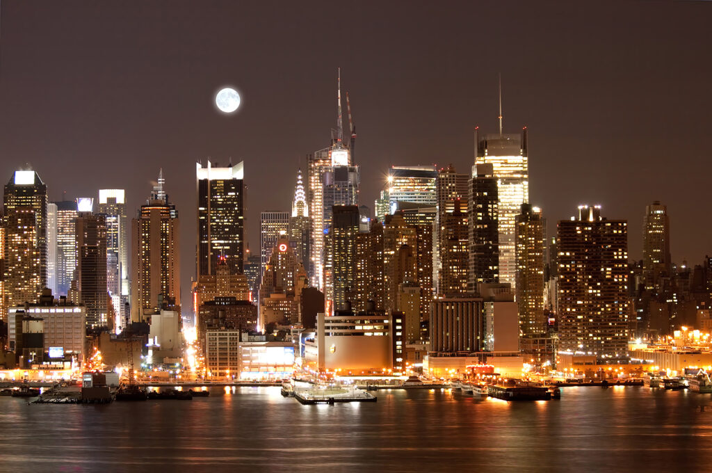 City skyline at night with the moon in the sky City skyline at night with the moon in the sky