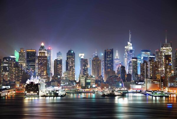 City skyline at night with lights reflecting on water City skyline at night with lights reflecting on water