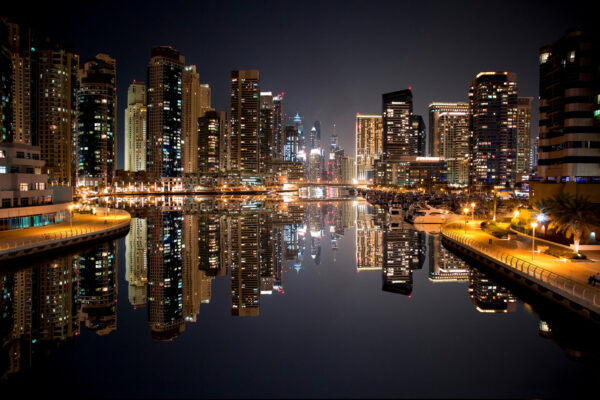 City skyline with lights reflecting on water City skyline with lights reflecting on water