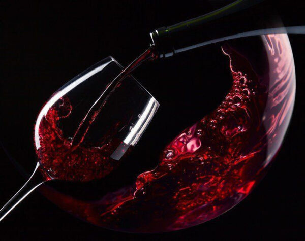 Glass of red wine being poured